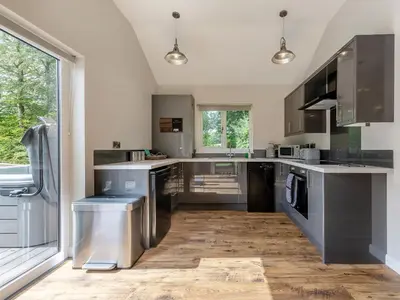 a kitchen with stainless steel appliances and a large window at Dwrgi - Uk32923 in Cwrt-newydd