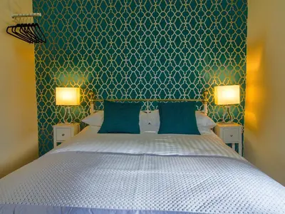 a bedroom with a white bed with two blue walls at Riverbank Bed and Breakfast in Llanwrtyd Wells
