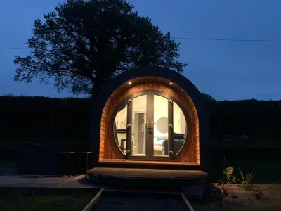 a small circular house with a round window at Great House Farm Luxury Pods and Self Catering in Crickadarn