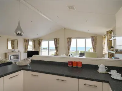a kitchen with a view of the ocean at The Potting Shed in New Quay
