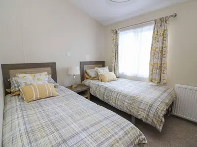 a bedroom with two beds and a window at The Potting Shed in New Quay