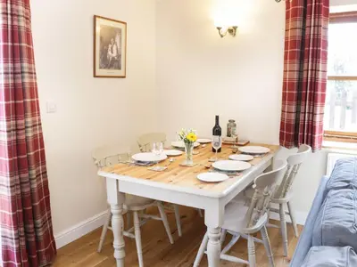 a dining room with a wooden table and chairs at The Cider House in Leominster