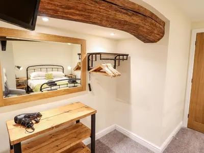 a mirror in a room with a bed and a table at Hen Dy Bryn Mawndy in Corwen