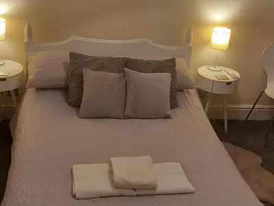 a large bed with pillows and towels on it at 2 Bodwen Villas in Llangollen