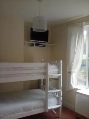 a bedroom with a white bed and a window at 2 Bodwen Villas in Llangollen