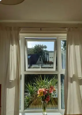 a window with a vase with flowers in it at 2 Bodwen Villas in Llangollen