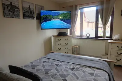 a bedroom with a bed and a flat screen tv on the wall at 15 Bronant in Talgarth