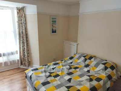a bedroom with a couch with a checkered blanket at 52 Cambrian St in Aberystwyth