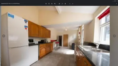 a kitchen with a white refrigerator and wooden cabinets at 52 Cambrian St in Aberystwyth