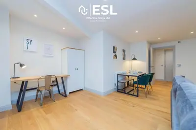 a living room with a table and chairs and a bed at Modern 2 Bedroom Church Apartment 5 Mins to Town Centre - Free Parking in Shrewsbury