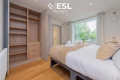 a bedroom with a large bed and a window at Modern 2 Bedroom Church Apartment 5 Mins to Town Centre - Free Parking in Shrewsbury