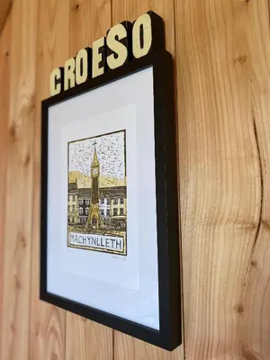 a picture of a framed picture on a wooden wall at Hillside hideaway - Hendre-Aur Pod in Machynlleth