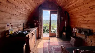 a kitchen with a large window in a wooden cabin at Hillside hideaway - Hendre-Aur Pod in Machynlleth