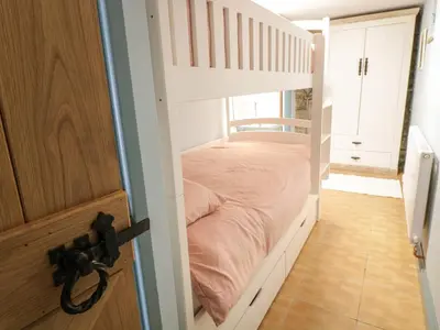 a white bunk bed in a room with a door at Brithgwm Canol in Dolgellau