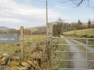 a gate on a country road with a fence at Brithgwm Canol in Dolgellau