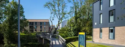 a building with a walkway next to a building at Fferm Penglais Apartments in Aberystwyth