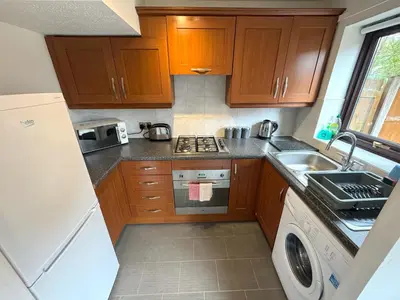 a small kitchen with a stove and a sink at 2 bed house, walking distance Shrewsbury centre in Shrewsbury