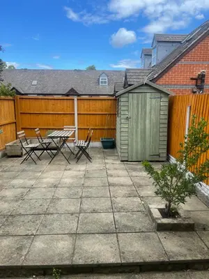 a patio with a wooden fence and a table and chairs at 2 bed house, walking distance Shrewsbury centre in Shrewsbury