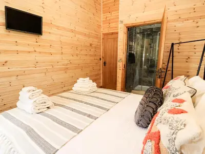 a bedroom with a bed with towels on it at The Larches in Llanidloes