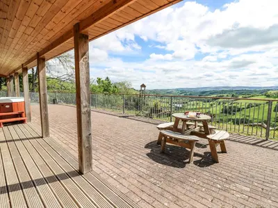 a patio with a table and a picnic table at The Larches in Llanidloes