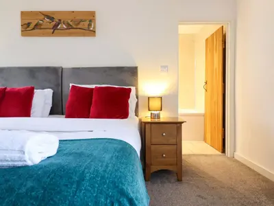 a bedroom with a large bed with red pillows at Bwthyn Y Bugail Shepherd's Cottage in Oswestry