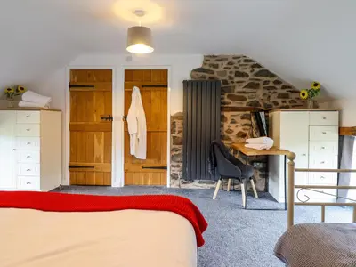 a bedroom with a bed and a desk in a room at Y Beudy The Dairy in Oswestry