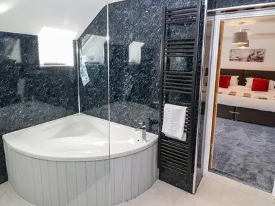 a bathroom with a shower and a bath tub at Y Beudy The Dairy in Oswestry