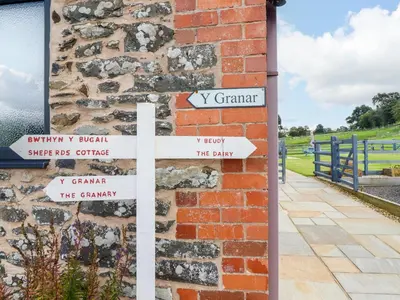 a brick wall with street signs on it at Y Beudy The Dairy in Oswestry