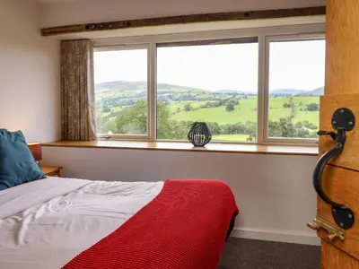 a bedroom with a bed and a window with a view at Y Granar The Granary in Oswestry