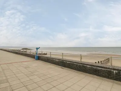 a boardwalk leading to a beach with the ocean at The Nook in Tywyn