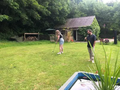 a man and a woman standing in a yard at Milkwood Cottage in Corwen