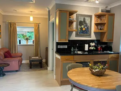 a kitchen and living room with a table and a tableablish at Milkwood Cottage in Corwen
