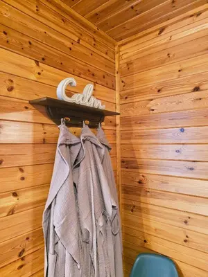 a room with a rack with a robe on a wall at Luxury Wood Lodge with sauna, log burner & private woodland garden - Wnion Wood Lodge in Llanfachreth