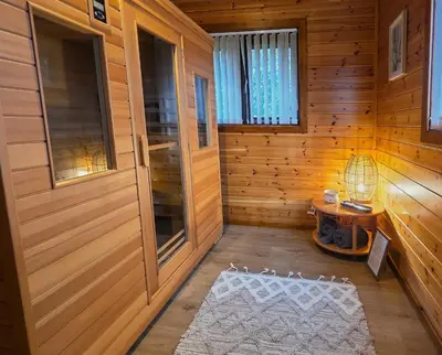 a room with a wooden cabin with a white rug at Luxury Wood Lodge with sauna, log burner & private woodland garden - Wnion Wood Lodge in Llanfachreth