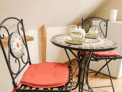 a small table with two chairs with cups and saucers on it at Milford Tree Tops in Craven Arms