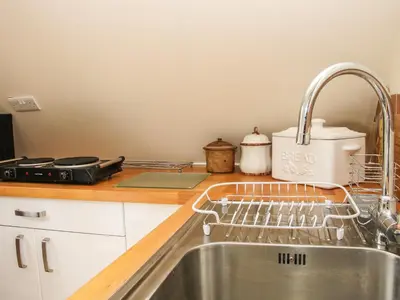 a kitchen sink with a dish drying rack next to it at Milford Tree Tops in Craven Arms