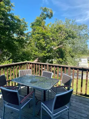 a patio table and chairs on a deck at The Oak Lodge in Aberystwyth