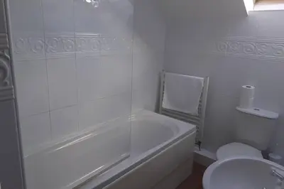 a white bathroom with a tub and a toilet at The Stable in Aberystwyth