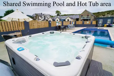 a swimming pool and a hot tub in a backyard at The Stable in Aberystwyth