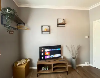 a living room with a flat screen tv on a wall at Westend Holiday Room 4 Brecon in Brecon