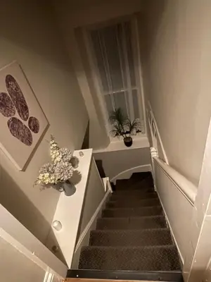 a stairway with a plant and flowers on a table at Westend Holiday Room 4 Brecon in Brecon