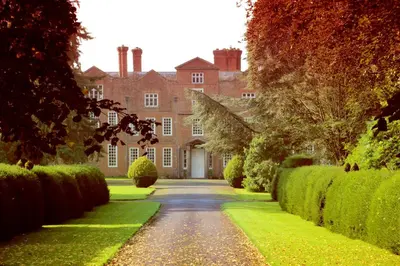 a driveway leading to a large house with green bushes at Henley Hall, Ludlow in Ludlow