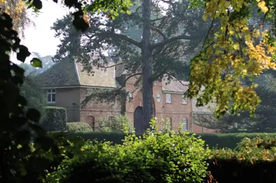 an old brick house with a tree in front of it at Henley Hall, Ludlow in Ludlow