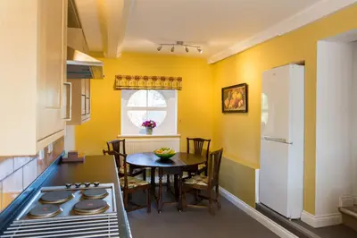a kitchen with a table and a white refrigerator at Henley Hall, Ludlow in Ludlow