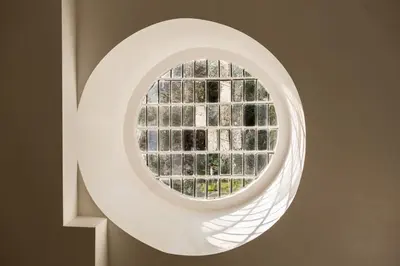 a round window in a white wall with a window at Henley Hall, Ludlow in Ludlow