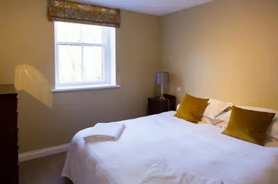 a bedroom with a large white bed with a window at Henley Hall, Ludlow in Ludlow