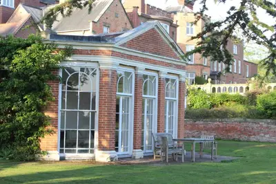 a house with a conservatory with a table and chairs at Henley Hall, Ludlow in Ludlow