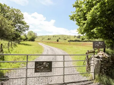 a gate leading to a dirt road with a sign at Hafotty Gelynen in Corwen