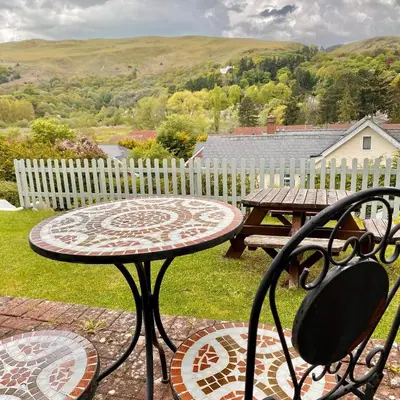 a table and a table and a bench on a patio at Hilltop Hut in Church Stretton