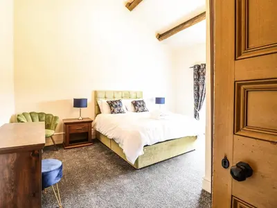 a bedroom with a bed and a desk and a chair at Bodaioch Hall in Caersws
